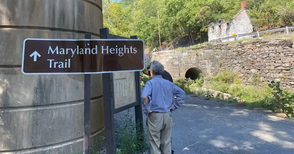 Visitors looking at map along the C&O Canal Towpath toward Maryland Heights in Harpers Ferry.